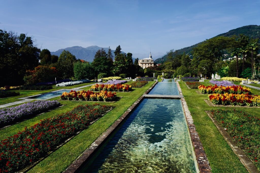Long reflecting pool in manicured gardens leading toward a villa near Lac Majeur