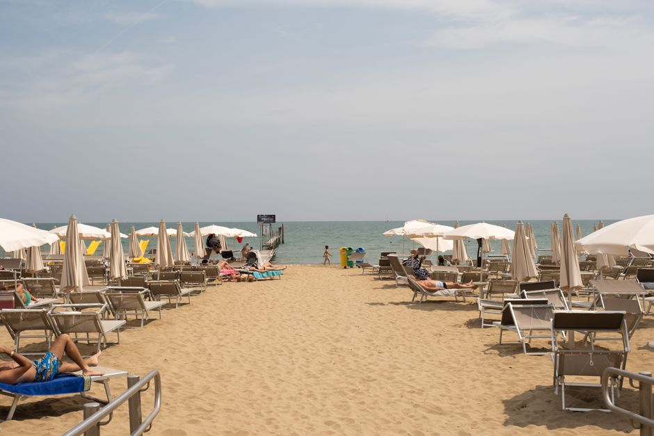 Plage de sable avec parasols et transats bordant le Lac Majeur