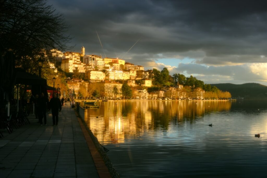 Abendliche Uferpromenade mit reflektierendem Dorflicht am Lago Maggiore