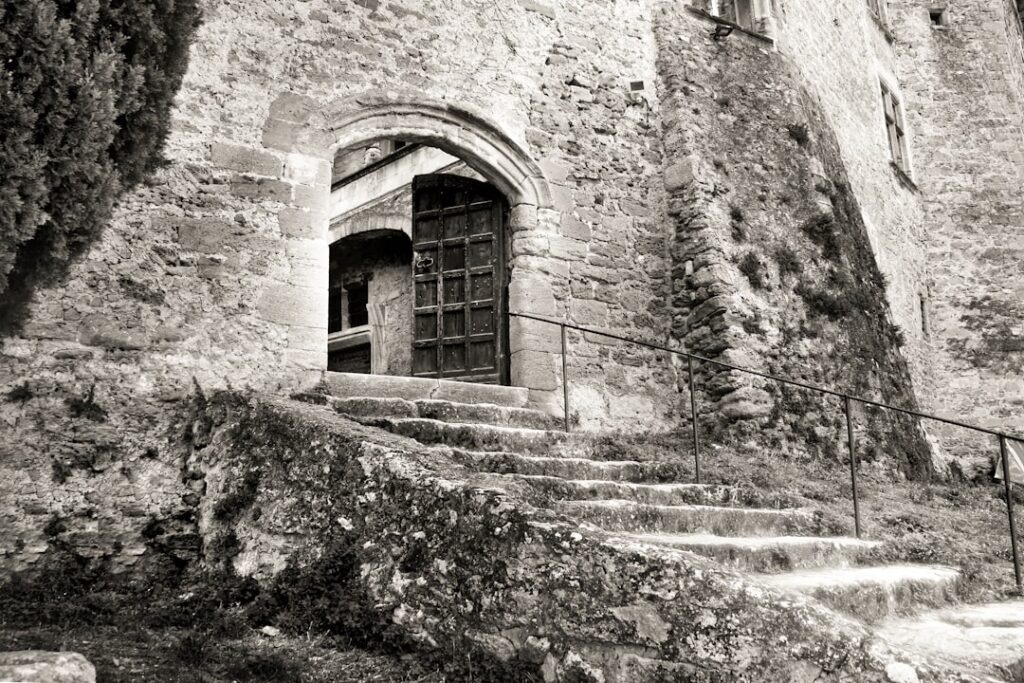 Steinige Treppe zur alten Holztür einer Burgmauer in Ombrien