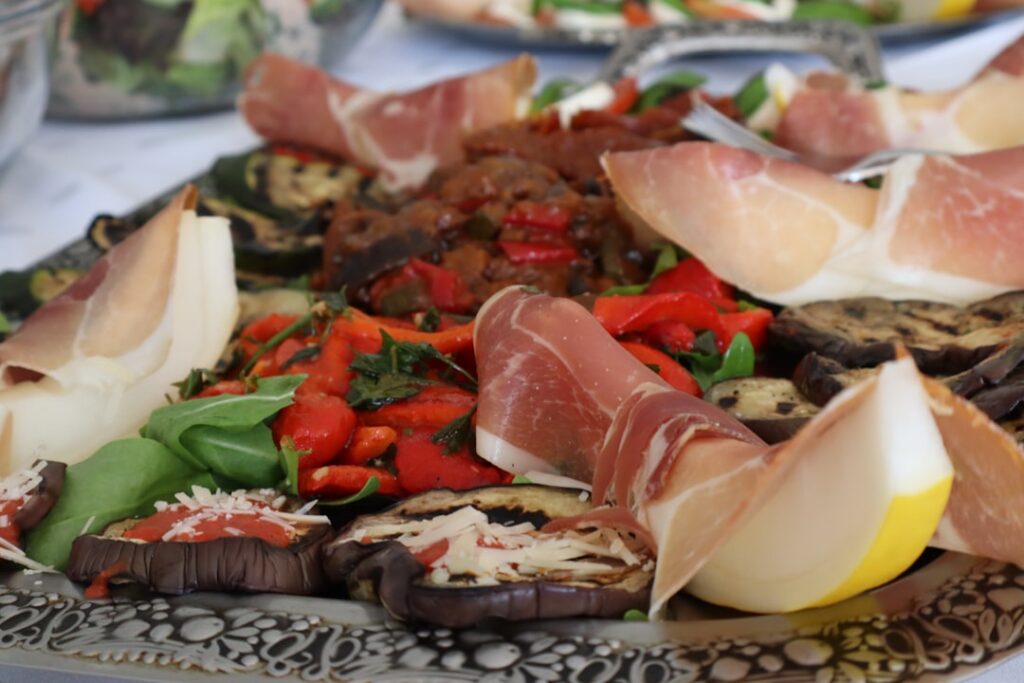 Vorspeisenteller mit Prosciutto, gegrilltem Gemüse und Rucola in Umbrien.