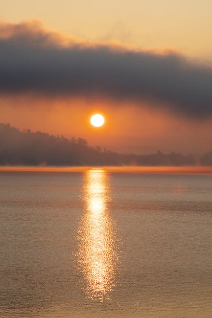 Alba sul Lago Trasimeno con rive avvolte nella nebbia