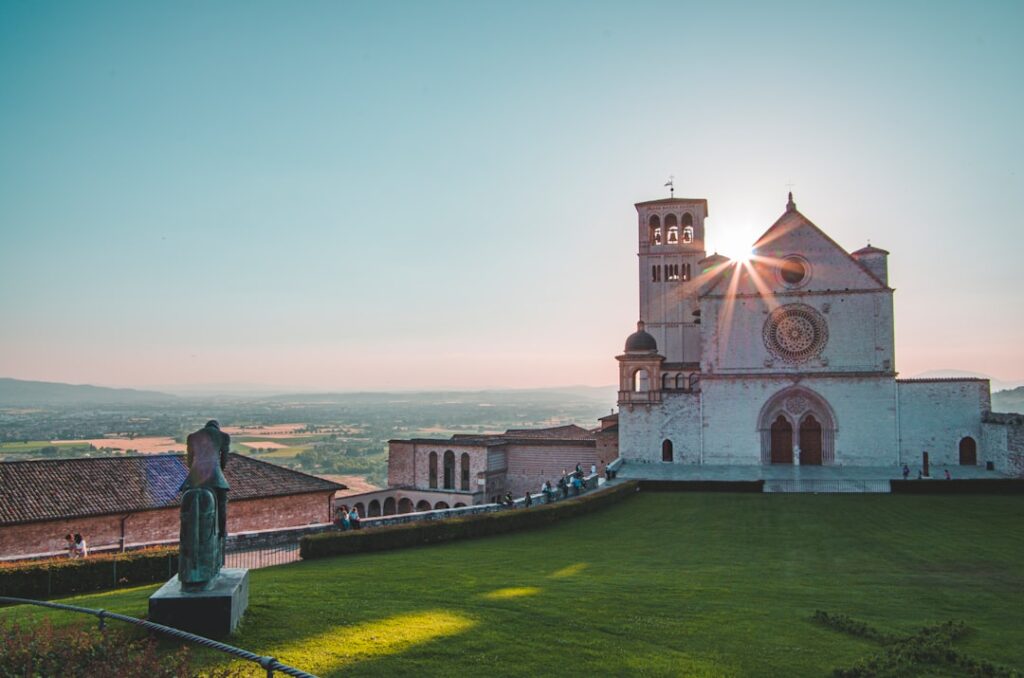 Basilica of Saint Francis in Assisi with sunburst over Umbria valley