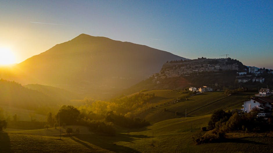 Sunrise over Umbria hills with a hilltop village beneath a mountain