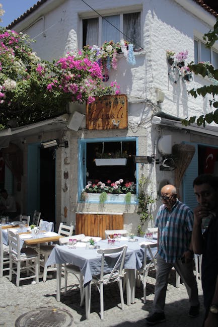 Tavoli all'aperto sotto bougainvillea davanti a una trattoria caratteristica