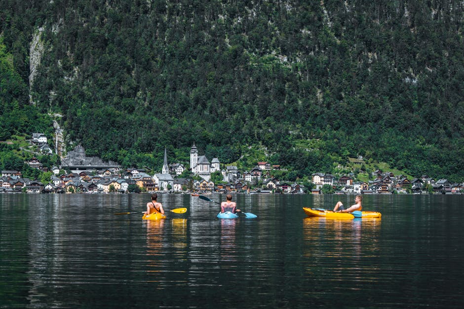 Trois kayakistes pagayant sur eau calme face au lac Trasimène, Ombrie