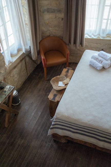 Simple retreat room with bed, chair and stone walls at Assisi