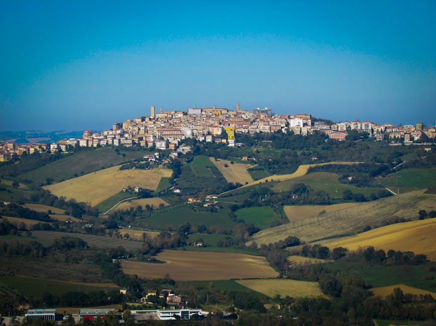 Distant Umbria hilltop town rising above patchwork cultivated fields
