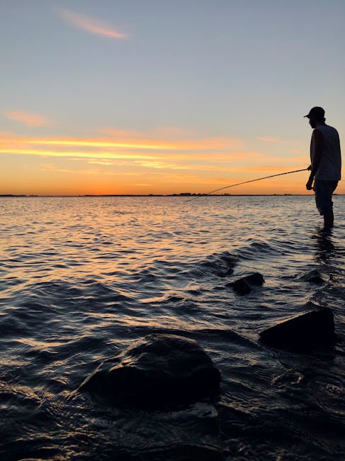Pescatore in piedi sulle rive del Lago Trasimeno al tramonto