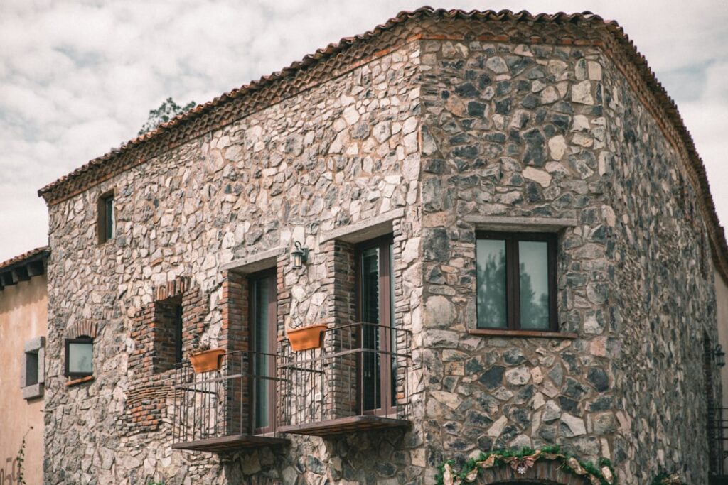 Rustic stone house in Umbria with narrow balconies and planters