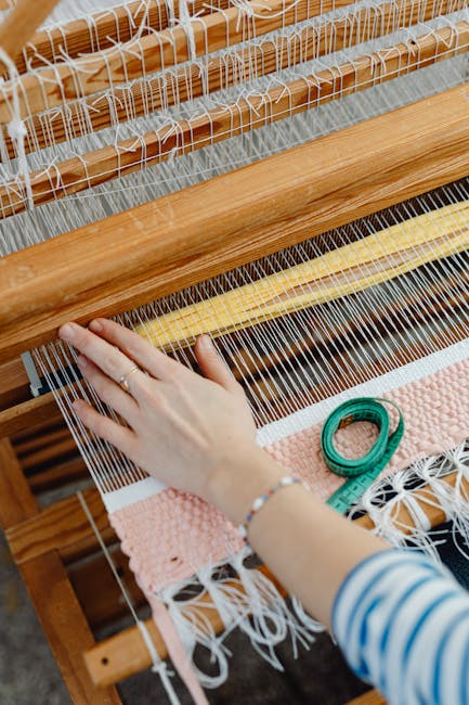 Hand werkt op houten weefgetouw met meetlint en textiel in Ombrie