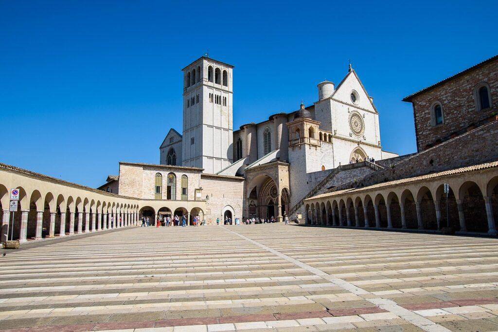 Grande basilique d'Assise avec clocher et arcades, ciel bleu en Ombrie