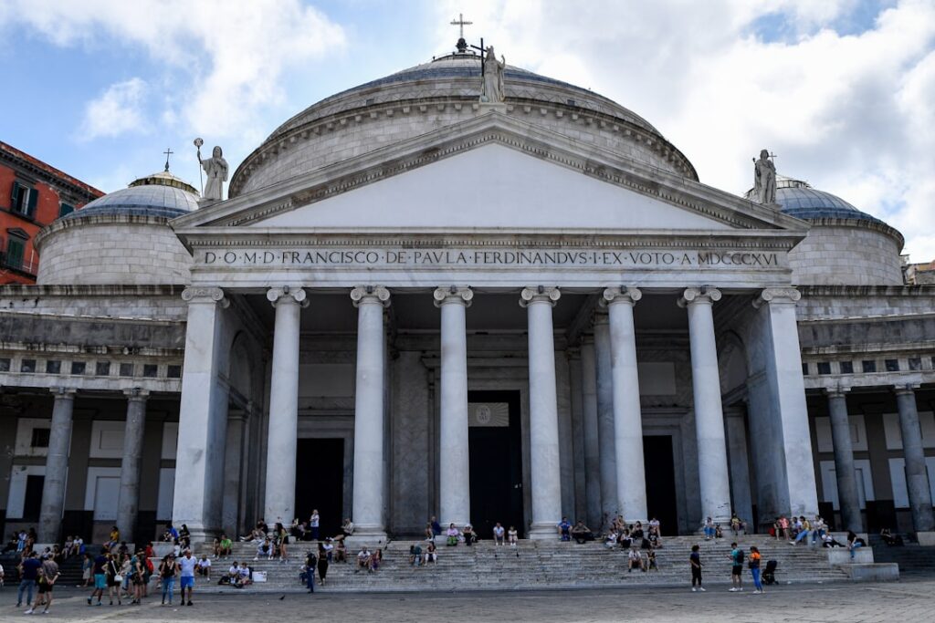 Facciata neoclassica con colonne e grande cupola, persone sulle scale