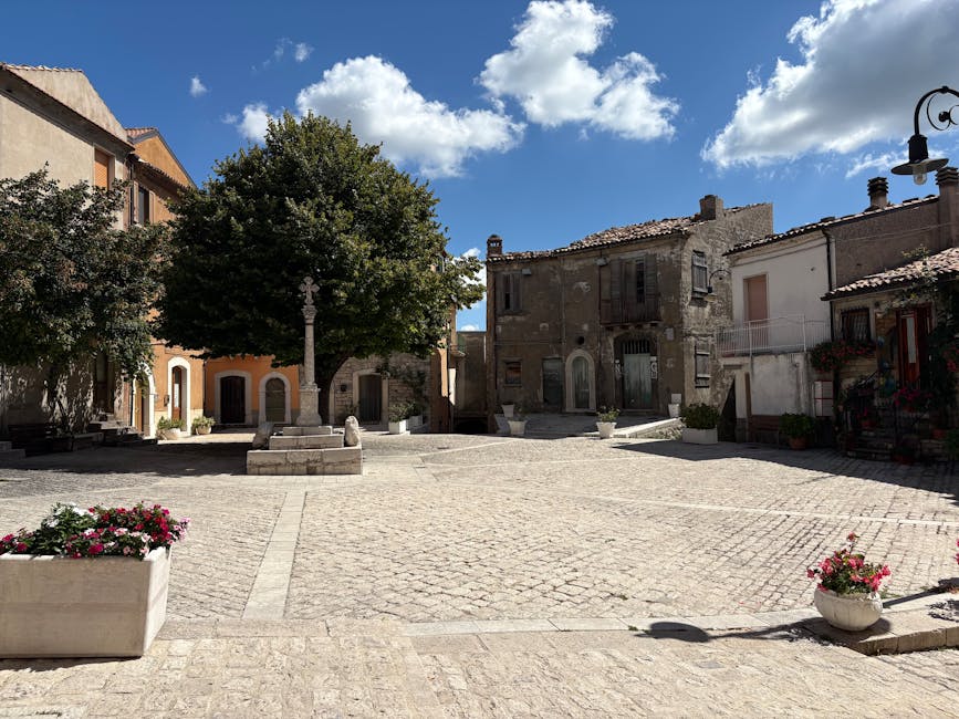 Quiet Umbrian piazza with stone trough, plane tree and weathered buildings