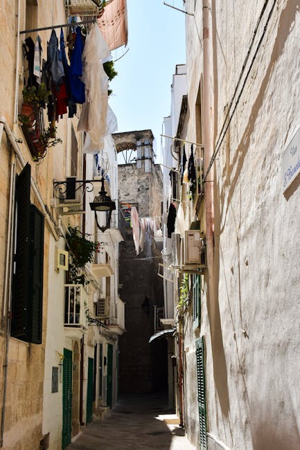 Sunlit narrow Umbrian alley with clotheslines strung between tall buildings