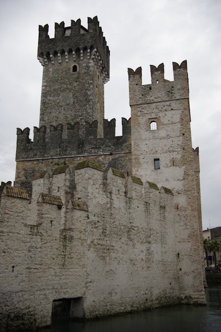 Torre e mura merlate di un castello medievale affacciato sull'acqua