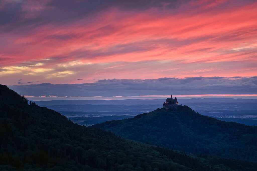 Château perché sur colline ombrienne sous ciel rose au crépuscule
