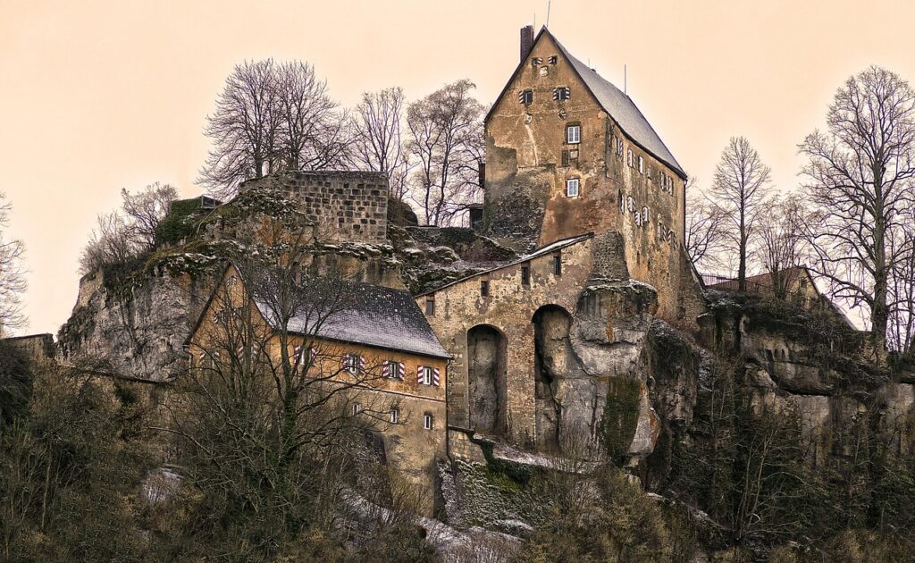 Château en ruine adossé à une paroi rocheuse, arbres dépouillés en Ombrie