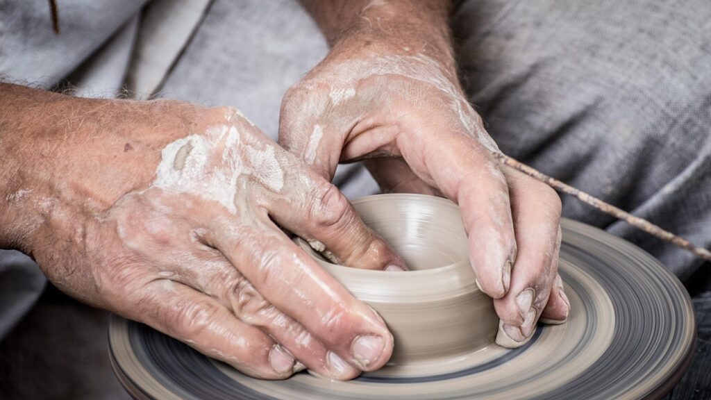 Garncarz szkliwi ceramikę w pracowni