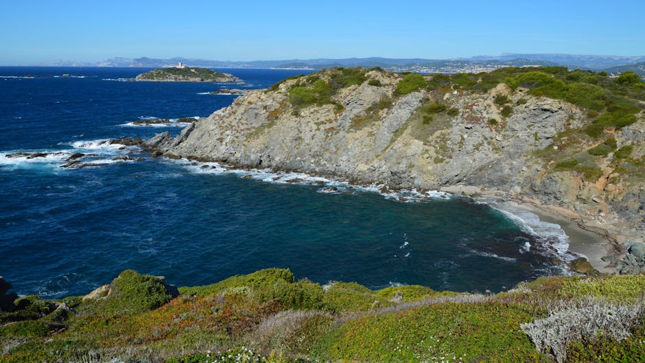 Baia rocciosa con scogli e acqua turchese, vegetazione costiera