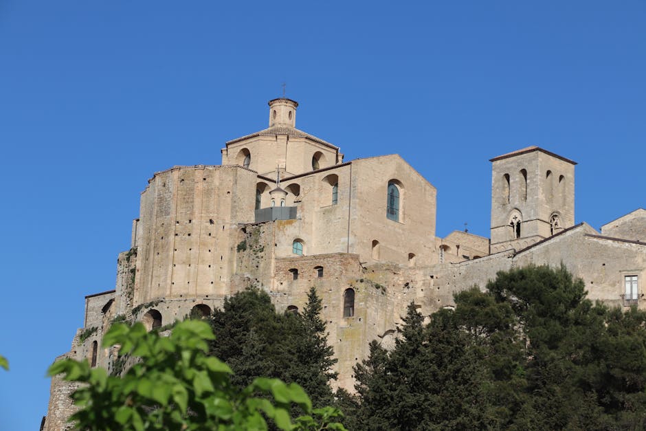 Antico monastero-fortezza su scogliera con cielo terso in Umbria