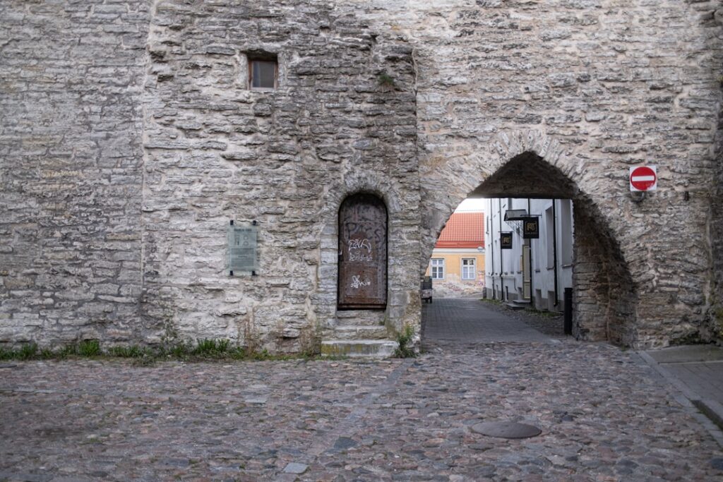 Worn stone gateway and arched pedestrian passage opening onto cobbled street, Umbria