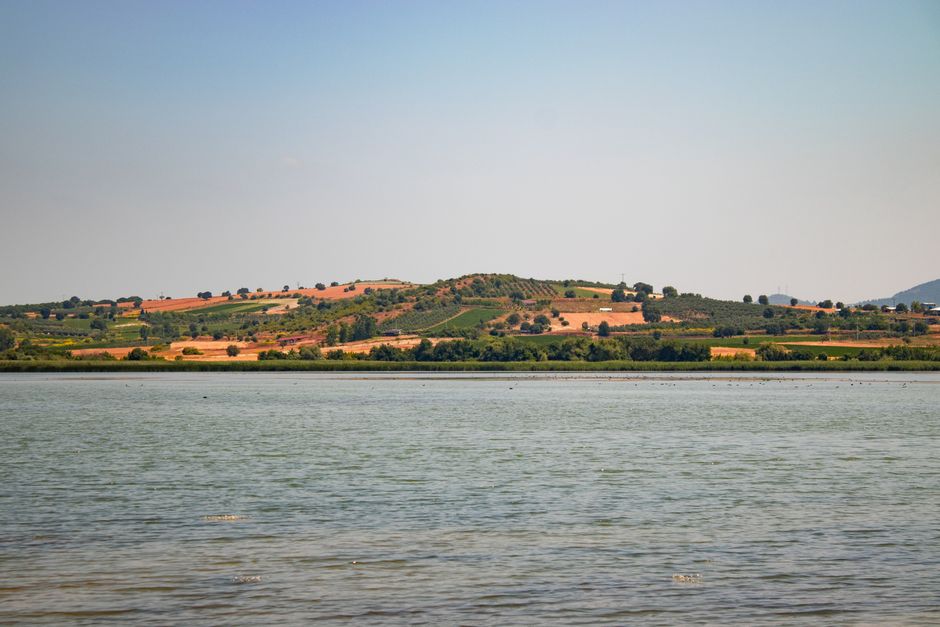 Lago placido e colline coltivate dell'Umbria sullo sfondo