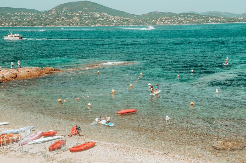 Plage avec kayaks et paddles, eaux turquoise et collines en Ombrie