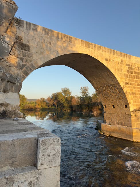 Arco di un antico ponte sull'acqua in Umbria al tramonto