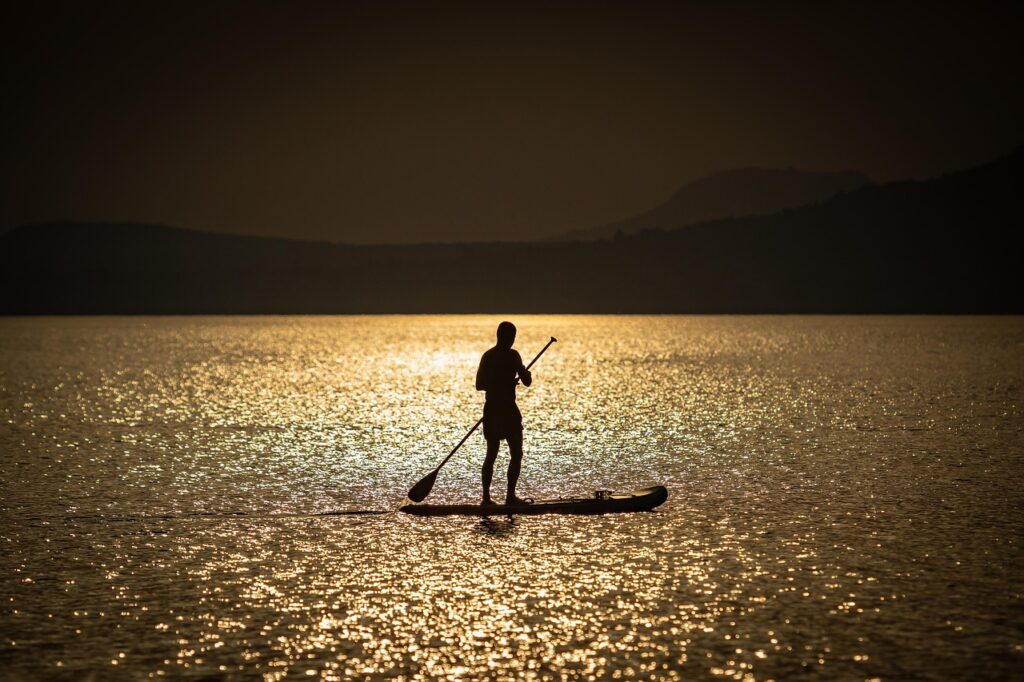 Silhouette d'un paddle au coucher du soleil sur le lac Trasimène
