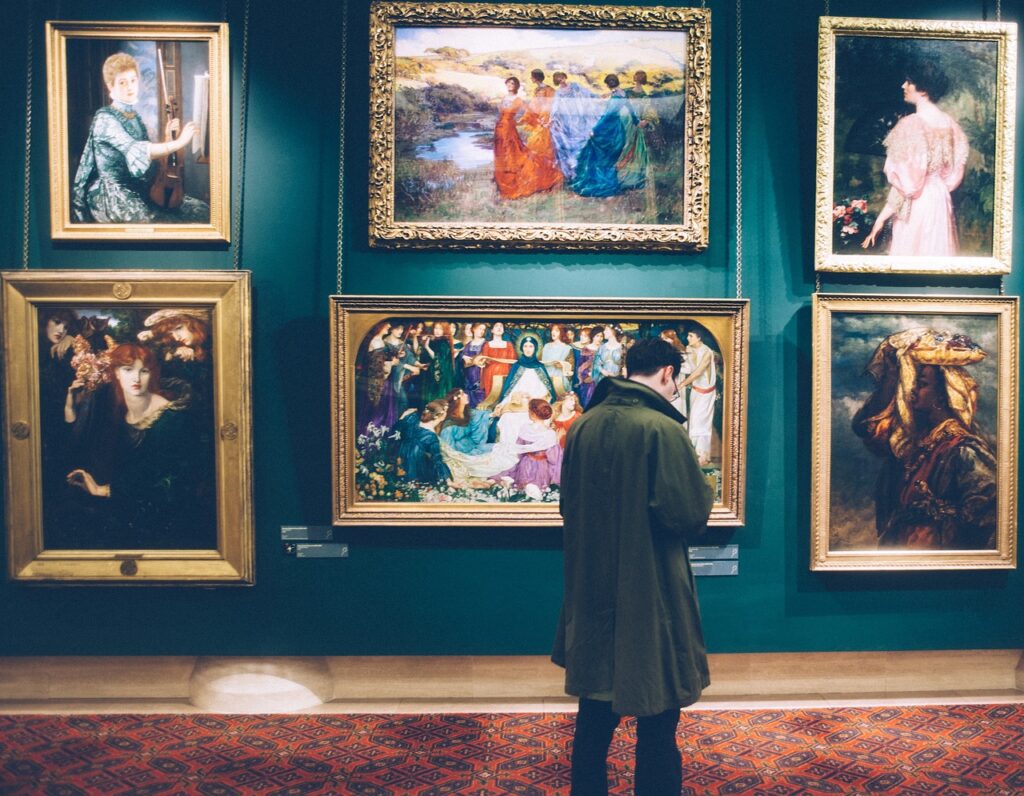 Visiteur devant peintures encadrées dans un musée de Pérouse