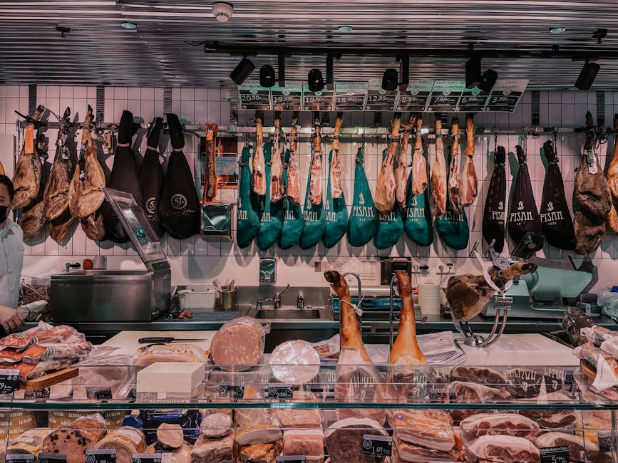 Deli counter with hanging cured hams and salumi in Calabria shop