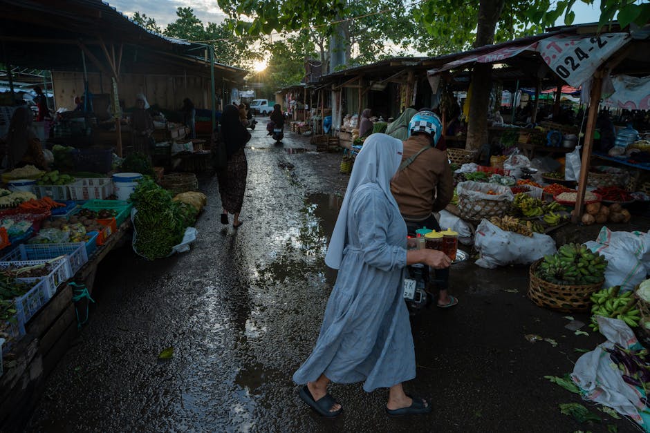 Busy outdoor produce market in Calabria with vendors and wet pavement