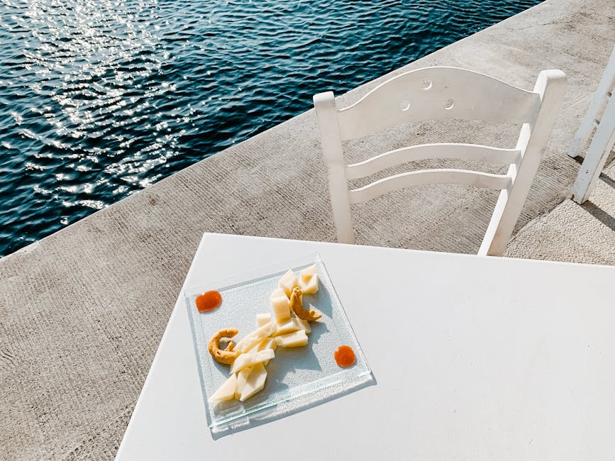 Kaasplankje op wit tafel bij glinsterend zeewater aan Calabrië-kust