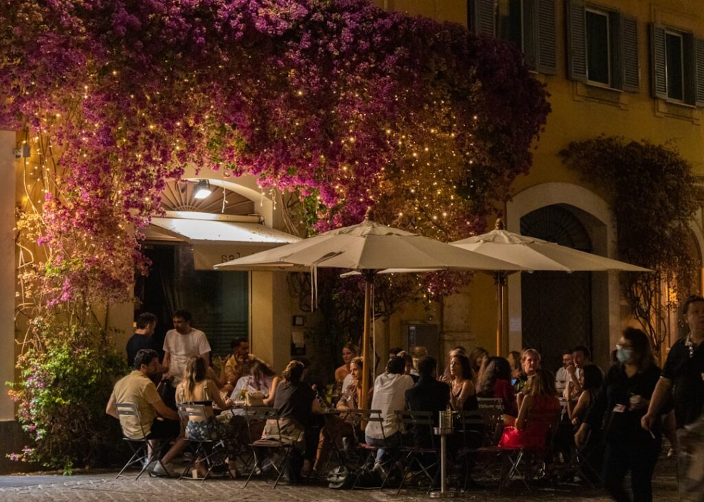 Outdoor restaurant under purple bougainvillea lights in Calabria evening
