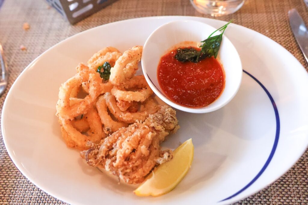 Assiette de calamars frits avec sauce tomate et quartier de citron en Calabre