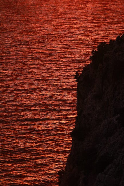 Rot leuchtendes Meer bei Sonnenuntergang an einer Steilküste in Kalabrien