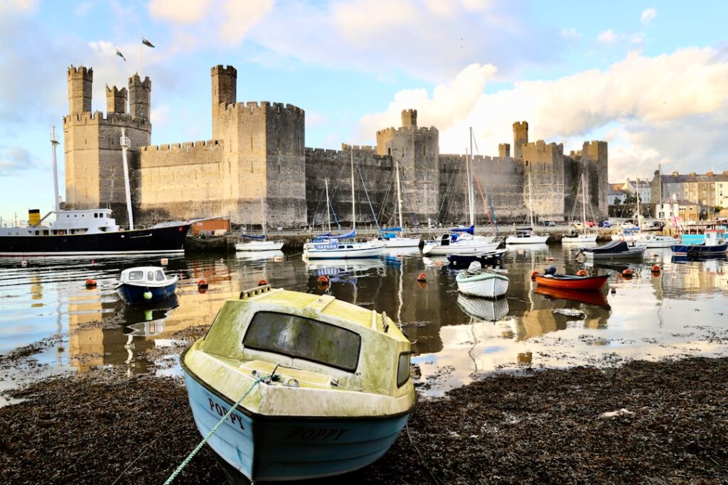 Château médiéval dominant un port calme avec plusieurs bateaux amarrés