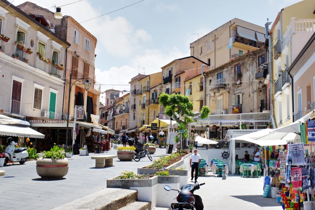 Belebte Piazza mit Cafés und bunten Häusern in Kalabrien.
