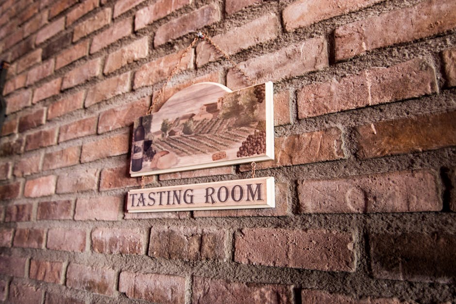 Holzschild 'Tasting Room' an Ziegelwand eines kalabrischen Weinguts
