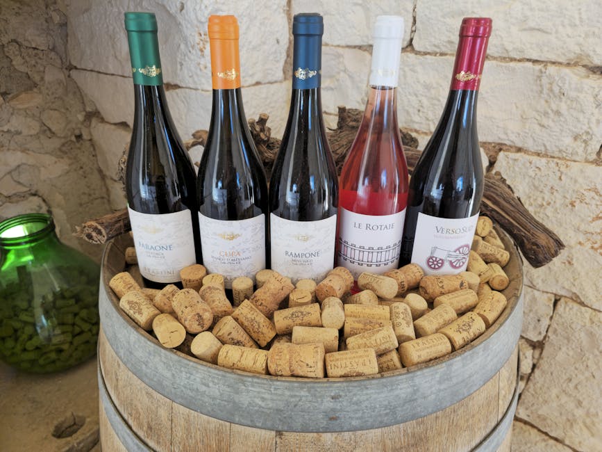Cinq bouteilles de vins locaux de Calabre posées sur tonneau rempli de bouchons