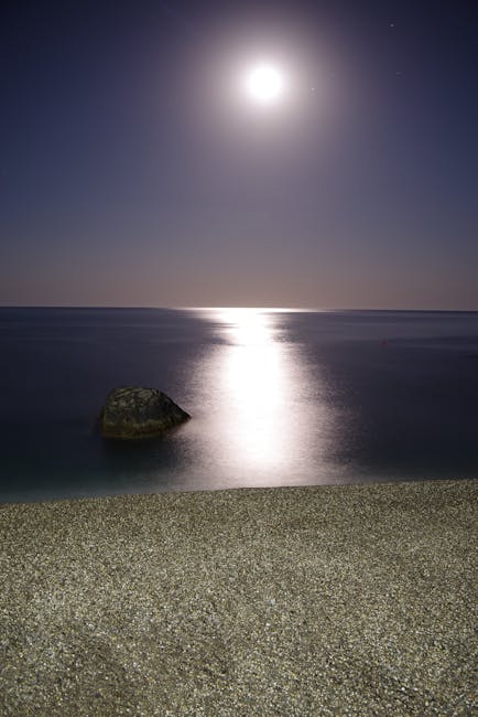Bright moonlight reflecting across Calabria sea onto a pebble beach