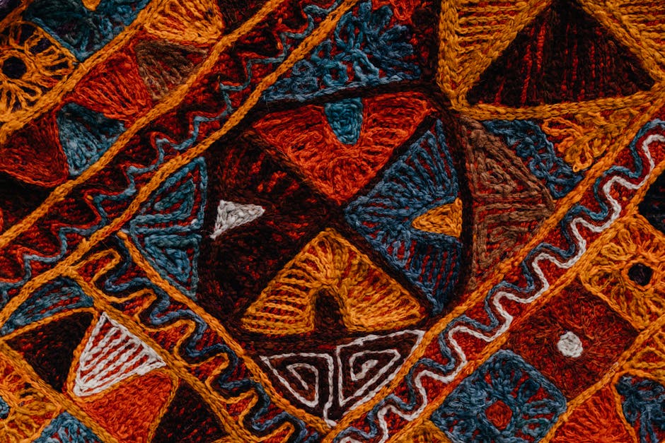 Détail de broderie colorée aux formes géométriques, tons chauds calabrais