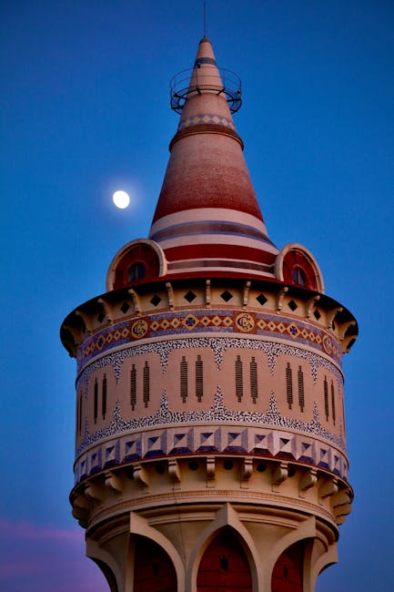 Decorative conical tower illuminated at dusk with moon over Calabria