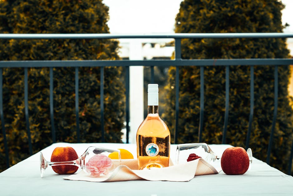 Roséflasche auf Tisch zwischen Reben in Paola