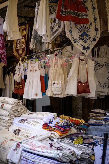 Étals de linge et petites robes brodées suspendues dans un marché calabrais