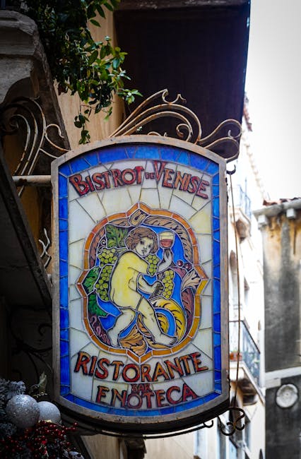 Buntes Ristorante-Enoteca-Schild mit Weinglasmotiv in einer Gasse Kalabriens