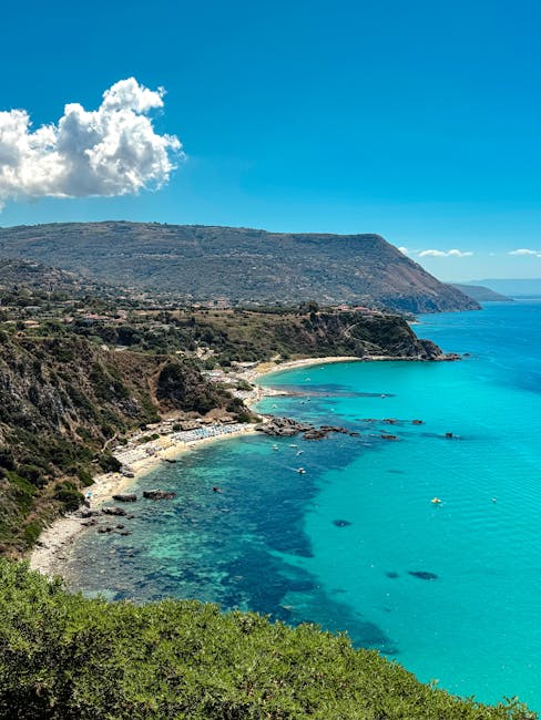 Baia rocciosa dalla costa calabrese con acqua turchese e scogli