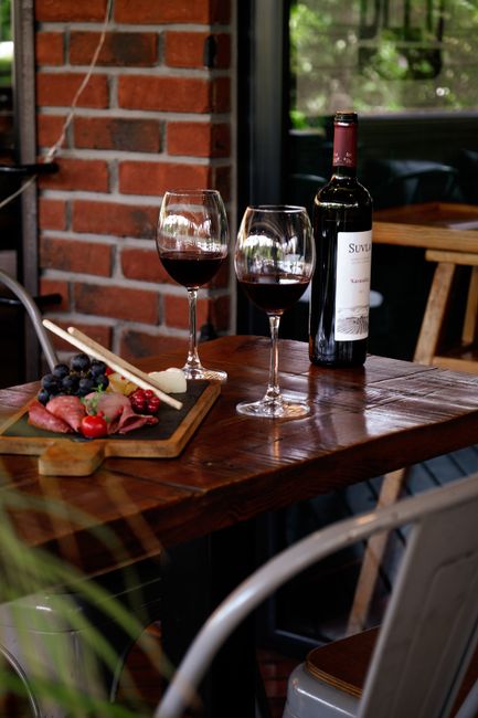 Zwei Gläser Rotwein, Flasche und Brett mit Antipasti in Kalabrien