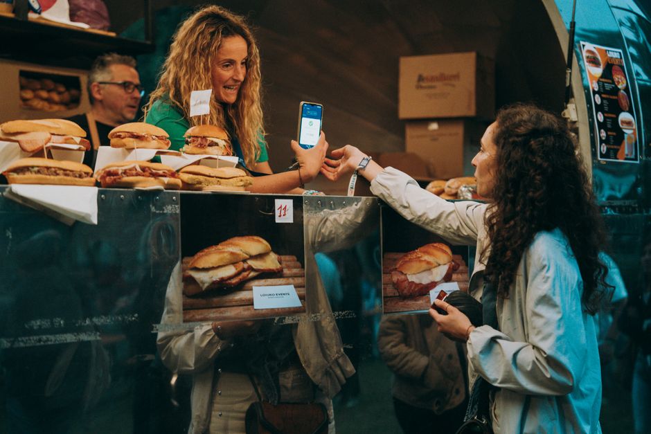 Client payant par smartphone au camion de street-food, sandwicherie de rue en Calabre